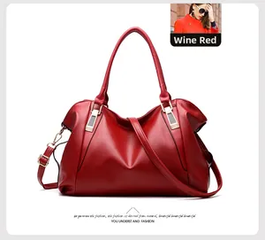 Detailed view of the burgundy pebbled leather handbag featuring gold-tone hardware