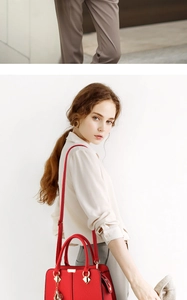 Detail of red lychee grain leather handbag with gold hardware and shoulder strap