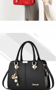 Close-up of litchi grain leather texture and elegant tassel pearl charm on the handbag