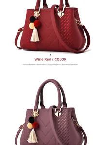 Details einer gesteppten V-Tasche mit dekorativem Pompon und Gold-Beschlägen in Weinrot