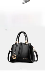 Close-up of black textured leather bucket bag with gold hardware and circular pendant