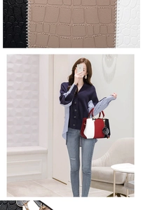 Detailed close-up of tri-color textured leather handbag with gold hardware and gray pompom