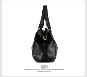Detail view of black lychee-grain leather tote featuring gold D-ring metal hardware