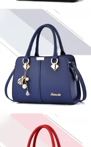 Detail view of royal blue and red pebble leather handbags with gold metallic hardware