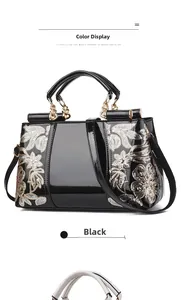 Detail of black patent leather bag with silver floral sequins and gold hardware