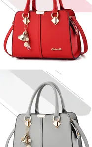Detail of red and grey faux leather handbags featuring litchi texture and gold hardware