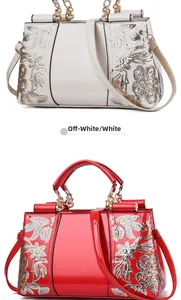Detail view of red and white patent leather bags with floral sequin embroidery and chain handle