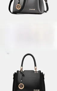 Detail of minimalist bucket bag in grey and black pebbled leather with gold hardware