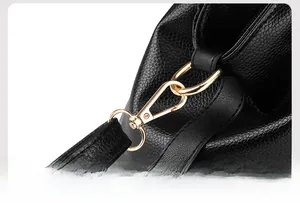 Detail of the black pebbled leather bag featuring a high-quality gold lobster clasp
