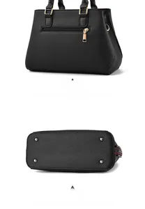Detailansicht einer schwarzen Handtasche mit Reißverschlussfach und Metallfüßen am Taschenboden