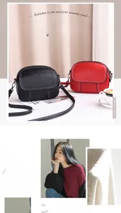 Détail de sacs bandoulière ronds avec coutures contrastées et boucles métal en noir et rouge