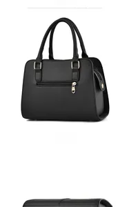 Detail view of black lychee grain handbag with gold heart-shaped zipper and back pocket