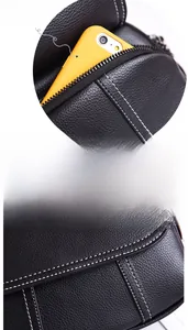 Détail du sac bandoulière en cuir noir avec coutures contrastées et poche pour téléphone