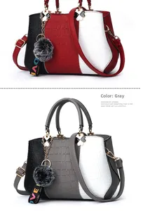 Detail view of women's tote bag with stone pattern texture and plush pompom charms