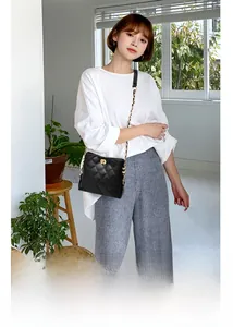 Details der schwarzen Stepptasche mit elegantem goldenem Drehverschluss und Kettenriemen