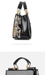 Detail of glossy black patent leather handbag with sparkling floral sequin embroidery