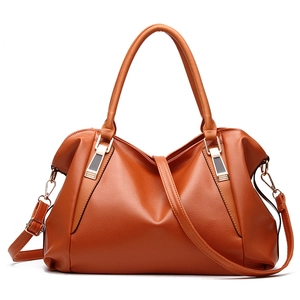 Caramel faux leather handbag with top handles and adjustable shoulder strap on white background