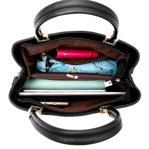 Black leather handbag featuring spacious interior compartments and multiple zipper pockets
