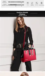 Detail view of red and black contrast handbag with metal pendant and adjustable strap