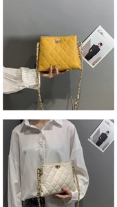 Detailed view of quilted leather chain bags in yellow and cream with CD metal buckles