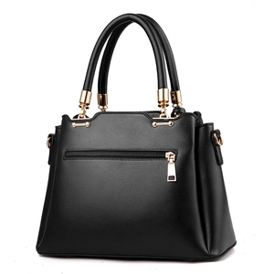 Classic black leather bucket bag with top handles and golden hardware on white background