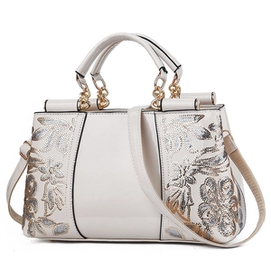 Glossy patent leather handbag in beige with elegant gold and silver floral embroidery