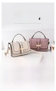 Close-up of elegant small square bags with golden H-buckle and textured faux leather finish
