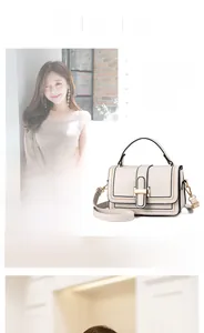 Detail of a beige small square crossbody bag with a gold buckle and adjustable strap