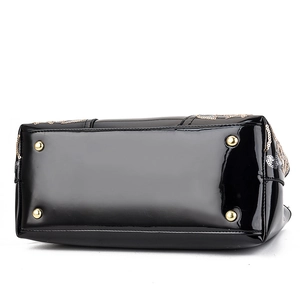 Glossy black patent leather handbag featuring gold bottom studs and sequin embroidery details