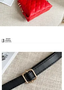 Detail einer roten Stepptasche mit Goldkette und verstellbarer schwarzer Schnalle