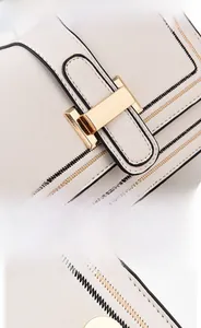Detail of premium hardware magnetic clasp and vegan leather texture on white crossbody bag
