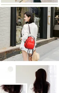 Close-up of red mini backpack with litchi texture and gold metal zippers for women