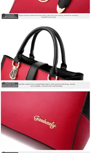 Detail of red and black leather handbag showing golden hardware and precision stitching