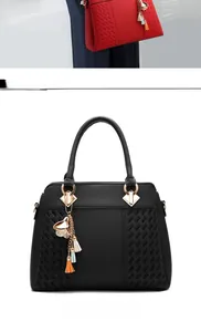 Detail of lychee pattern leather bag with gold hardware and colorful tassel charms