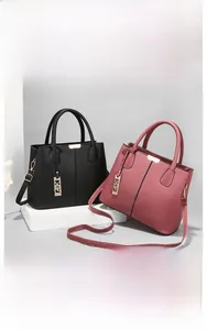 Detail of classic black and dusty pink tote bags with lychee pattern and gold hardware