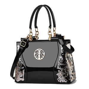 Retro black patent leather handbag with floral embroidery and gold metal logo charm