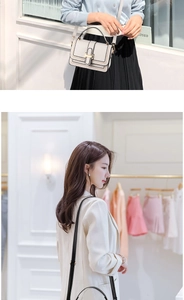 Detail of a minimalist cream crossbody bag featuring a golden buckle and fine stitching