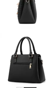 Detail of black pebbled faux leather handbag featuring colorful fringe and gold hardware