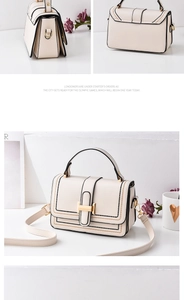 Detail view of cream leather crossbody bag with black trim and gold clasp lock