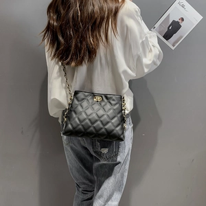 Chic black quilted crossbody bag with gold chain strap shown on a person’s back
