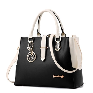 Women's chic contrast color handbag in black and white leather with gold heart pendant