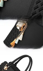 Detail of black PU leather handbag with woven texture and colorful tassel charm