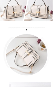 Detail view of cream handbag with striped trim and gold H-buckle on minimalist background