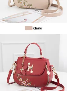 Close-up of floral embroidery, pearl H-buckle and butterfly charm on the bucket bag