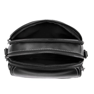 Sac bandoulière noir rond avec trois zips, cuir grainé et surpiqûres blanches contrastées