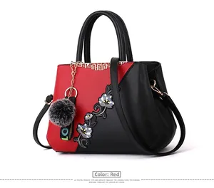 Close-up of contrast color embroidery and premium red faux leather texture on tote bag