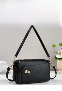 Dettaglio borsa in pelle nera a grana litchi con tre strati e finiture dorate