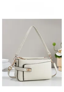 Dettaglio borsa a mano in pelle litchi bianca con chiusura in metallo dorato e decori
