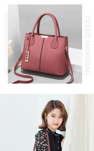 Detail of pink lychee leather handbag with gold hardware and removable shoulder strap