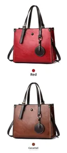 Detail view of large vintage tote bags in red and caramel with contrast stitching
